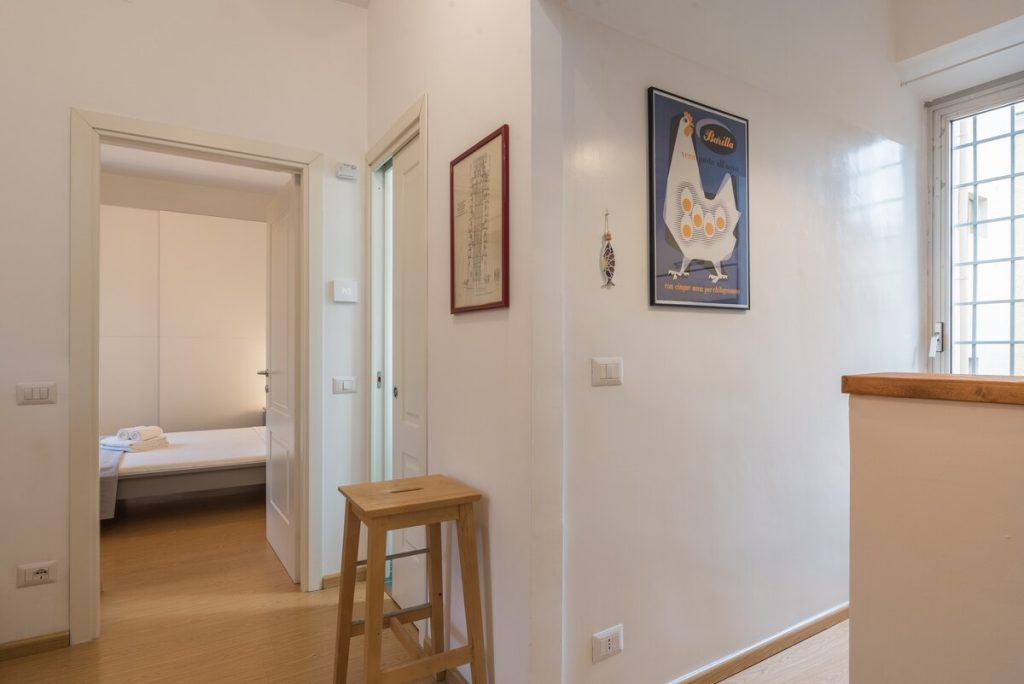 Il corridoio d'ingresso, con la porta aperta sulla camera da letto e la finestra a destra